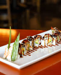 Avocado dragon roll drizzled with eel sauce and sesame