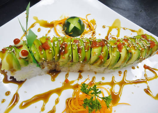 Close-up of a hand-rolled avocado dragon roll