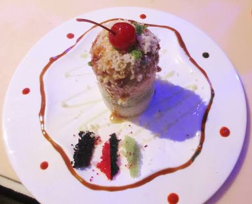 Tempura dessert topped with a cherry and candy garnish